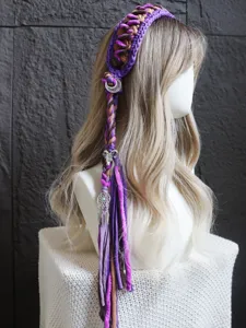 Cerchietto intrecciato all'uncinetto con nappe colorate e ciondoli boho, vista dettagliata.