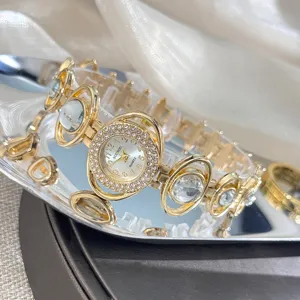 Close-up detail of luxury gold women rhinestone quartz watch with unique geometric link bracelet.