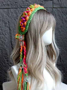 Primo piano della fascia per capelli boho all'uncinetto con trecce colorate e ciondoli.