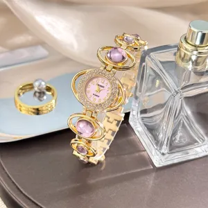 Detailed view of women fashion quartz watch with pink dial rhinestone bezel and purple stone bracelet.