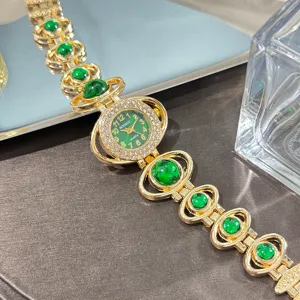 Detailed view of women's gold quartz watch with green stone beads and rhinestone dial.