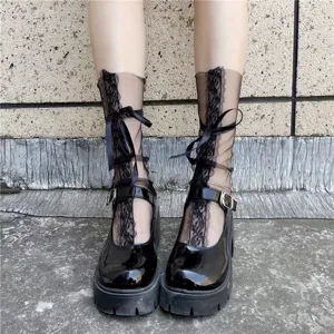 Calzini trasparenti in pizzo nero con nastri decorativi abbinati a scarpe platform.