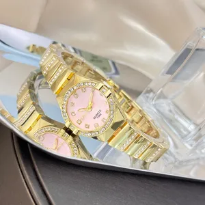 Close-up of luxury women quartz watch with pink dial rhinestone bezel and gold bracelet.