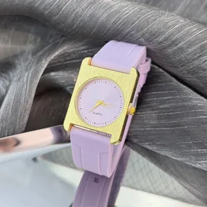 Modische rechteckige Quarzuhr mit lila Silikonarmband und goldenem Gehäuse für Damen.