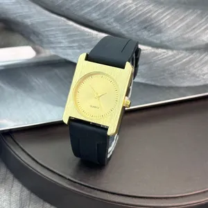 Modische quadratische Quarzdamenuhr mit gebürstetem Goldgehäuse und schwarzem Silikonarmband.