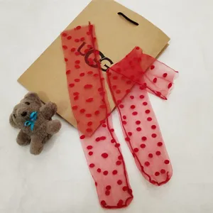 Red sheer mesh polka dot socks detail showing lightweight transparent fabric and soft velvet dots.