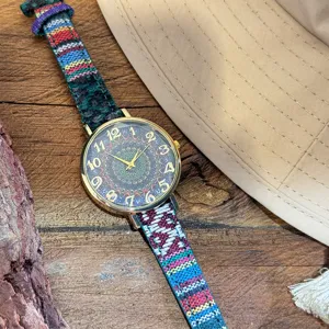 Close-up detail of bohemian style women quartz watch with colorful woven canvas strap dial.