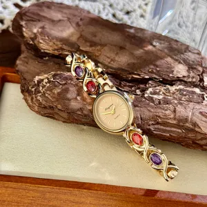 Vintage gold quartz watch with colorful oval gemstone bracelet for elegant daily wear.