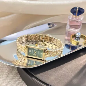 Detailaufnahme der vintage rechteckigen grünen Zifferblatt Uhr mit goldenem Blasenarmband.