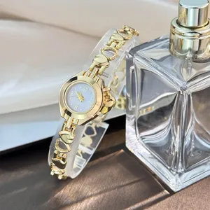 Delicate gold-tone quartz watch featuring a charming hollow heart link bracelet design for women.