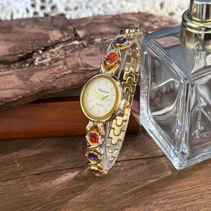 Detailed shot of gold quartz watch with colorful gemstone inlaid bracelet vintage style.