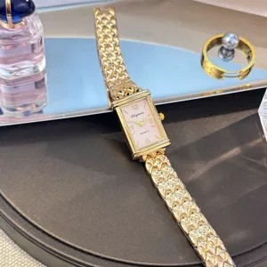 Vintage goldene rechteckige Quarzuhr für Damen mit rosafarbenem Zifferblatt und Armband.