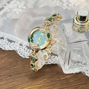 Reloj de cuarzo para mujer con esfera de madreperla verde y elegante pulsera dorada con brillo.