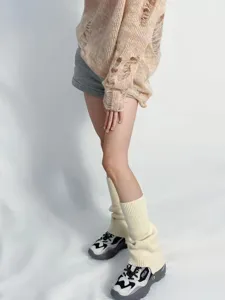 Vista detallada de calentadores de punto con textura crema cómoda y estilo elegante.
