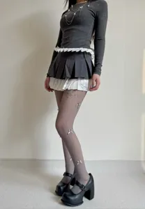 Detailed shot of grey fishnet tights with 3d bows, ballet style women legwear apparel.