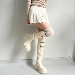 Close up detail view of stylish platform boots and comfortable knee high socks, soft texture.
