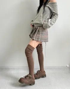 Detailed view of women long brown ribbed over-the-knee slouchy socks, autumn winter wear.