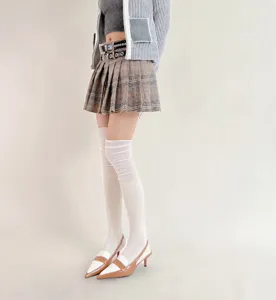 Detailed shot of women's ribbed over-the-knee high socks paired with stylish fashion outfit.