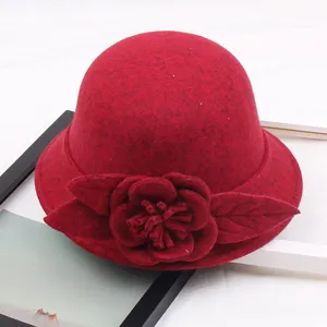 Close-up detail of the red felt cloche hat featuring 3D handmade floral decoration.