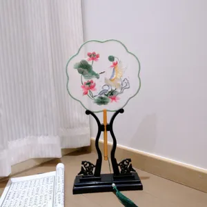 Traditional Chinese embroidered round fan detail with elegant lotus and crane pattern, vintage tassel.