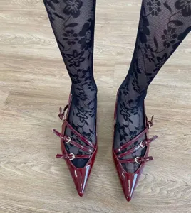 Elegant black floral lace tights paired with stylish burgundy patent leather pointed shoes.