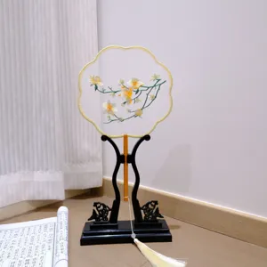 Traditional Chinese embroidered round fan with wooden stand and elegant tassel decor.