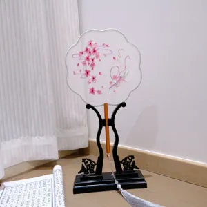 Embroidered round fan detail with pink floral mesh and wooden handle, elegant Hanfu prop.