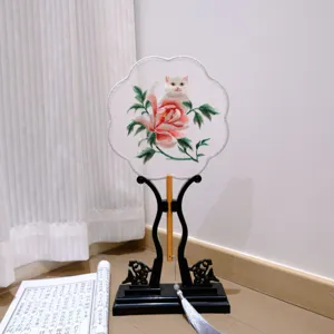 Detailed view of the traditional Chinese embroidered round fan featuring cute cat and peony.