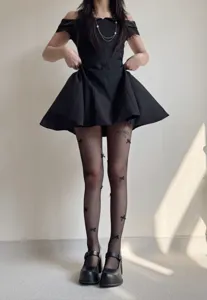 Detail shot of women's black fishnet tights with cute 3d bows, sweet style leg wear.