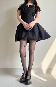 Detail view of fishnet pantyhose featuring handmade 3D black bows, perfect for balletcore style.
