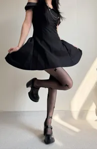 Close-up detail of women's black fishnet pantyhose featuring 3D bow accents and stylish look.