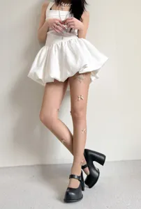 Detail shot of women's fishnet tights with handmade 3D bows, balletcore style hosiery.
