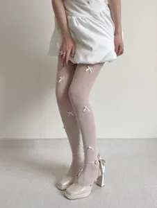 Close-up detail of women's fishnet pantyhose featuring 3D bow knots for ballet core style.