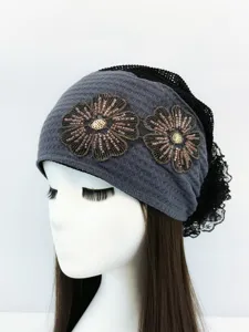 Vista dettagliata ravvicinata del copricapo turbante con fiori di perline boho grigio con retro pizzo.