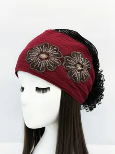 Vista di dettaglio della fascia per capelli rossa boho con fiori di perline e retina.