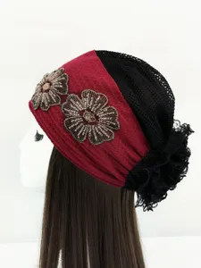 Vista dettagliata dell'elegante turbante da donna in rete floreale perlinata, bordo in pizzo.