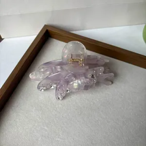 Pince à cheveux coquillage transparente en acétate détail avec strass exquis et ressort métallique.
