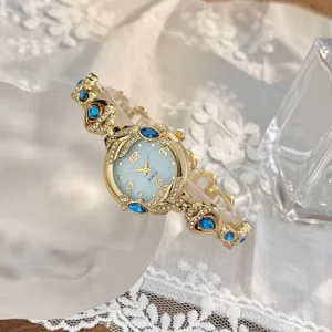 Detalle en primer plano de reloj de cuarzo para mujer, esfera azul y brillos.