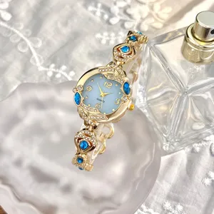 Primer plano de reloj de cuarzo de lujo para mujer, pulsera de diamantes y esfera azul.