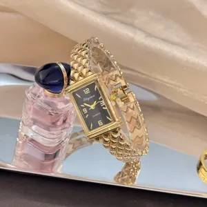 Nahaufnahme der Vintage rechteckigen Quarzuhr mit strukturiertem goldenem Armband.