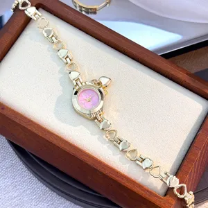 Elegant gold quartz watch featuring a hollow heart link bracelet and pink dial, dainty design.