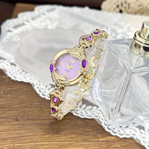 Reloj de cuarzo dorado para mujer con esfera morada y pulsera brillante decorada con finos cristales.