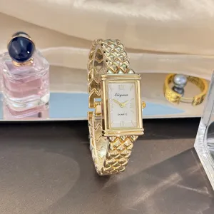 Detailansicht der Vintage rechteckigen Quarzuhr mit goldenem Blasenarmband und weißem Zifferblatt.
