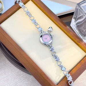 Elegant quartz watch with hollow heart bracelet strap, cute pink dial and charm for women.