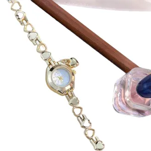 Chic hollow heart pendant bracelet quartz watch for women, elegant jewelry timepiece.
