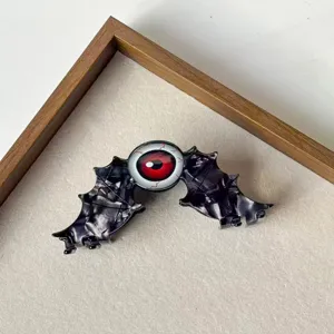 Gotische Fledermaus Flügel Haarklammer mit rotem Augapfel Design für Halloween und Alltag.
