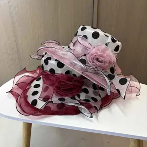 Nahaufnahme des Polka-Dot-Organza-Sonnenhuts mit mehrschichtigen Rüschen und Blumen.