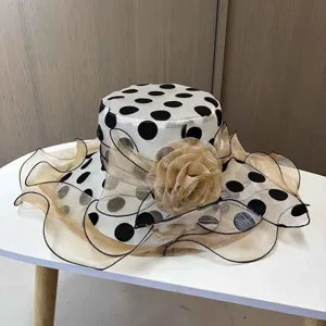 Nahaufnahme des eleganten schwarz-weißen Pünktchen-Sonnenhuts mit feiner Organzablume.