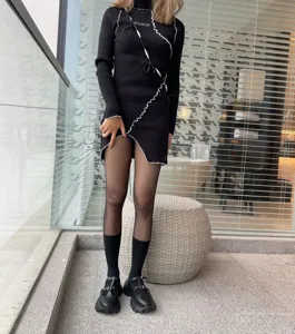 Detailed shot of black knit dress and sheer tights showcasing sweet cool fashion style.
