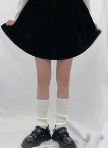 Detailed view of white slouch leg warmers paired with black platform shoes for a cozy winter look.